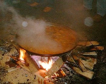 communal paella being cooked over a wood fire